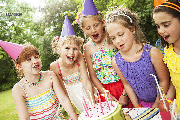 Mädchen bewundern Kuchen bei Geburtstagsfeier im Freien