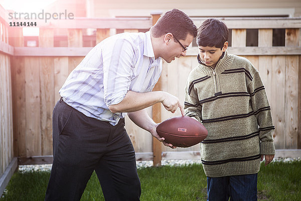 Hispanischer Vater bringt seinem Sohn das Fußballspielen bei