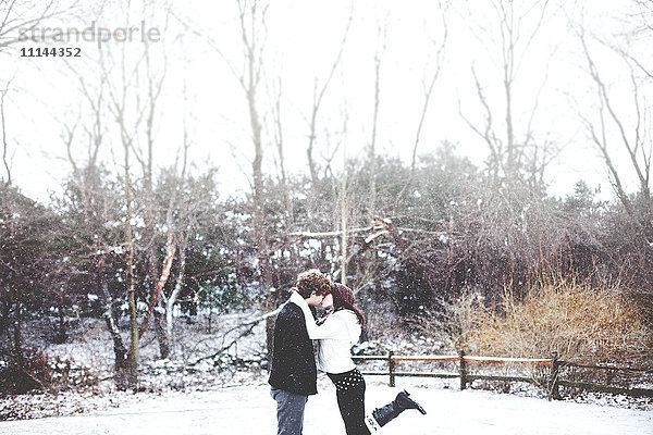 Paar küsst in verschneiten ländlichen Feld