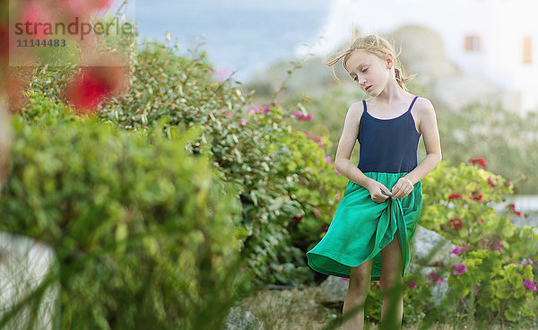 Kaukasisches Mädchen geht in einem Blumenfeld