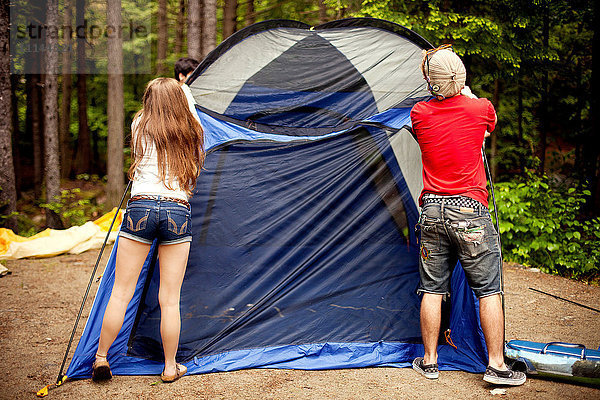 Ehepaar beim Zeltaufbau auf dem Campingplatz