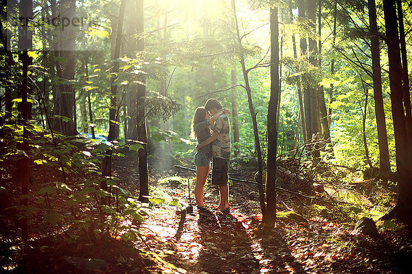 Paar  das sich im sonnigen Wald umarmt