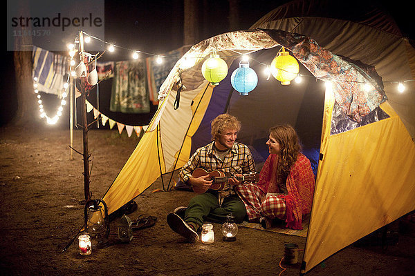 Pärchen spielt nachts Musik im Campingzelt