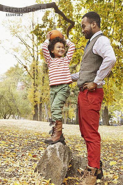 Vater und Sohn halten Kürbis im Park