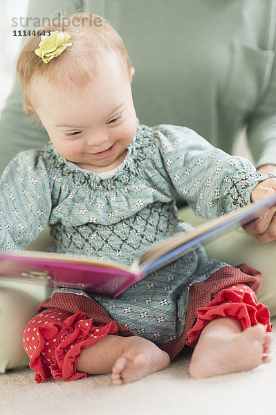 Kaukasisches Mädchen mit Down-Syndrom liest