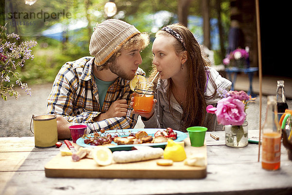 Ehepaar teilt sich eine Limonade am Picknicktisch im Wald