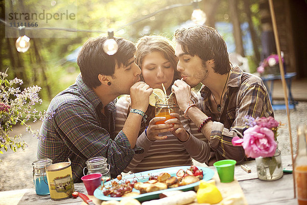 Freunde teilen sich eine Limonade am Picknicktisch im Wald