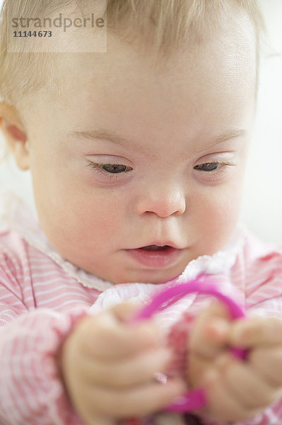 Kaukasisches Mädchen mit Down-Syndrom spielt mit Ring