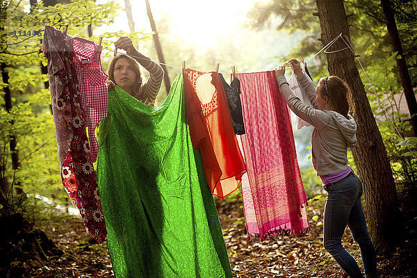 Mädchen hängen Wäsche auf einer Wäscheleine im Wald auf