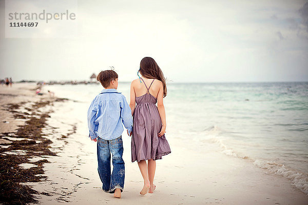 Bruder und Schwester gehen am Strand spazieren