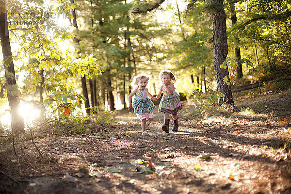 Mädchen laufen auf einem Waldweg