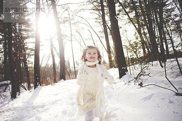 Kaukasisches Mädchen läuft im verschneiten Wald