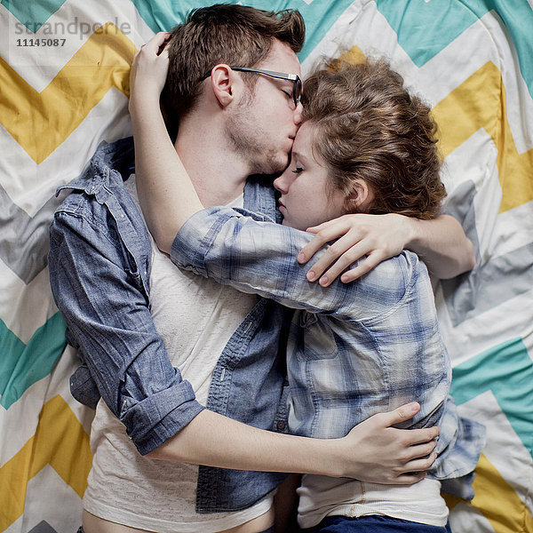 Hohe Winkel Ansicht von kuschelnden Paar auf dem Bett