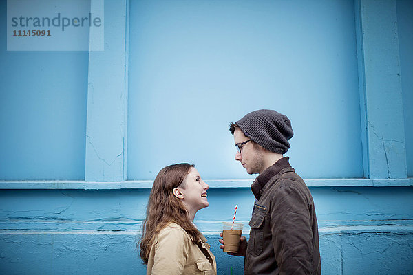 Paar steht in der Nähe der blauen Wand