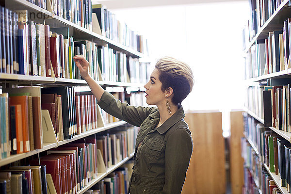 Frau sucht ein Buch in der Bibliothek