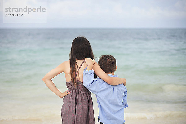 Bruder und Schwester umarmen sich am Strand