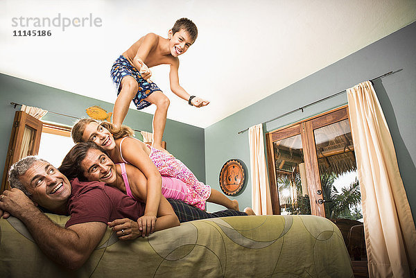 Familie spielt zusammen auf dem Bett