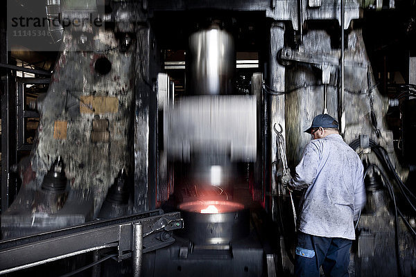 Kaukasischer Arbeiter  der in einer Fabrik Stahlschmelzmaschinen bedient