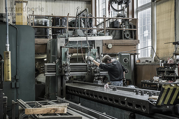 Kaukasischer Mann bei der Arbeit mit Maschinen in einer Metallwerkstatt