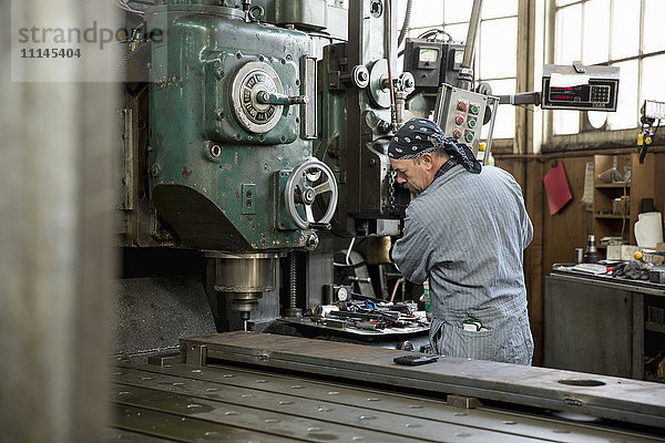 Mann an einer Maschine in einer Metallwerkstatt