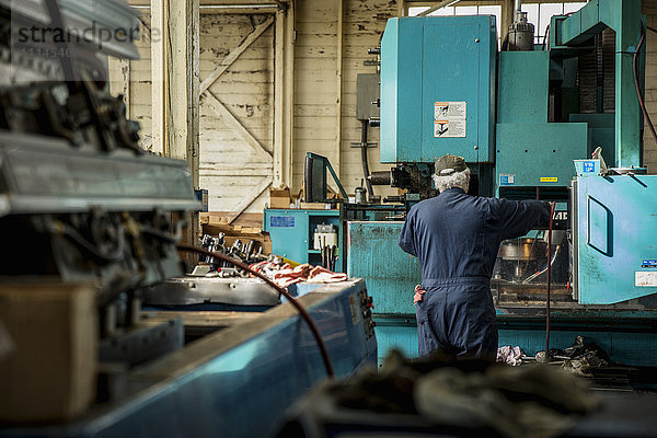 Kaukasischer Mann bei der Arbeit mit Maschinen in einer Metallwerkstatt