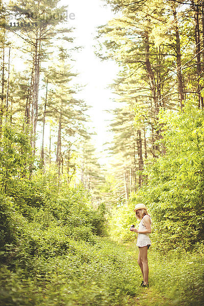 Kaukasische Frau geht auf Grasweg im Wald