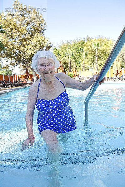 Ältere kaukasische Frau geht im Schwimmbad