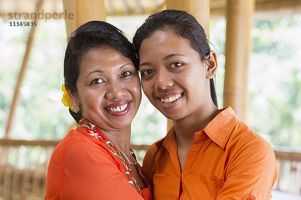 Balinesische Mutter und Tochter umarmen sich