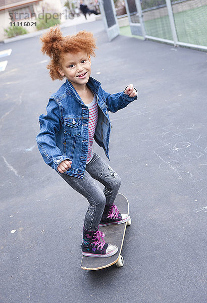 Mädchen fährt Skateboard im Stadtpark