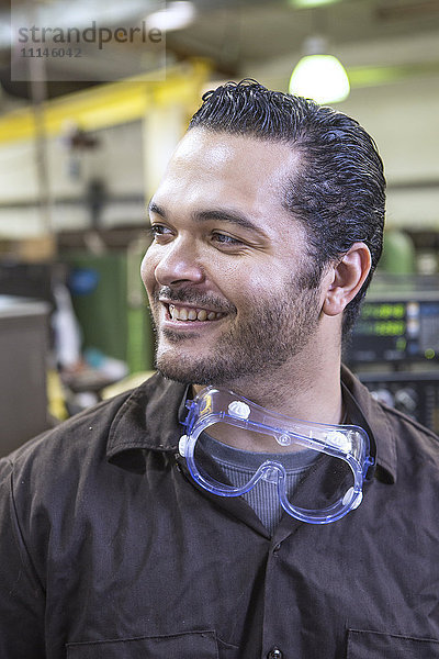 Hispanischer Arbeiter lächelt im Lagerhaus