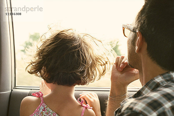 Vater und Tochter schauen aus dem Autofenster