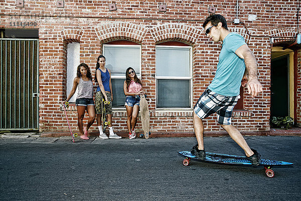 Freunde fahren Longboards in der Stadt