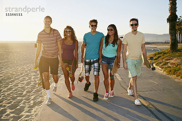 Freunde gehen zusammen am Strand spazieren