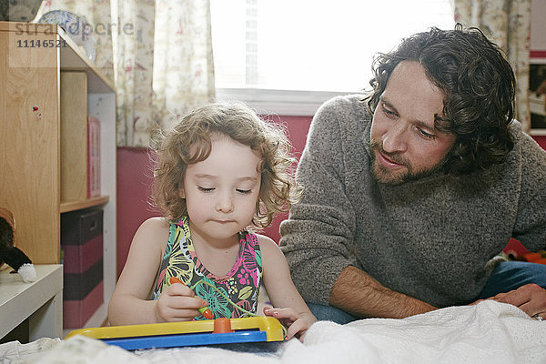 Kaukasischer Vater und Tochter spielen im Schlafzimmer