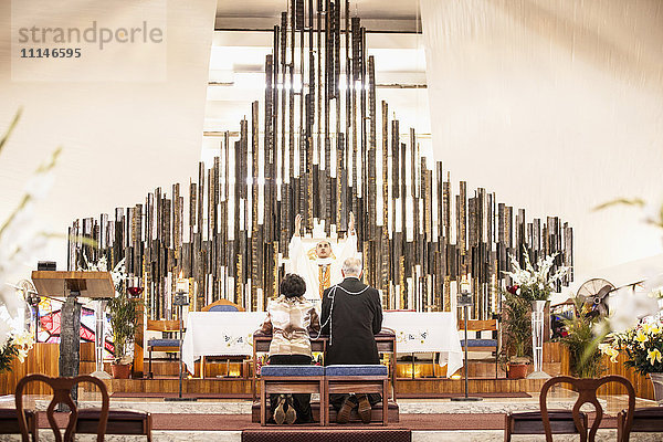 Ehepaar betet bei der Hochzeit in der Kirche