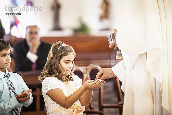 Mädchen bei ihrer Erstkommunion in der Kirche