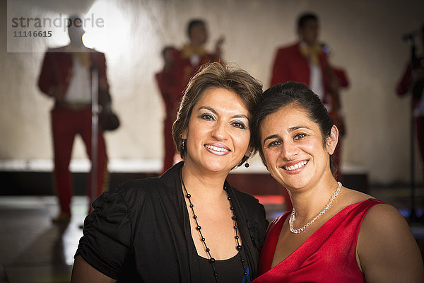 Lächelnde hispanische Frauen beim Hochzeitsempfang