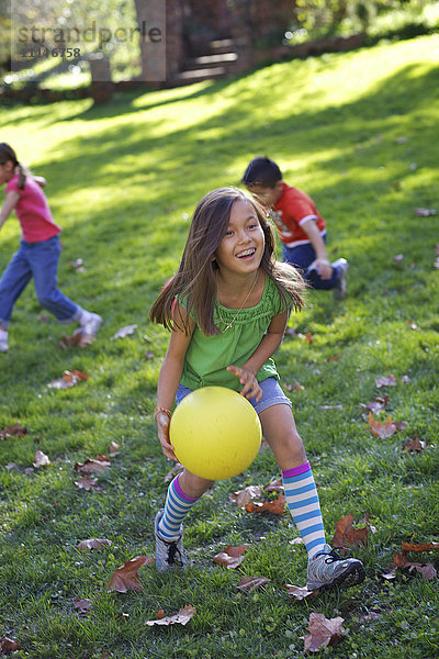 Kinder spielen mit Ball im Park