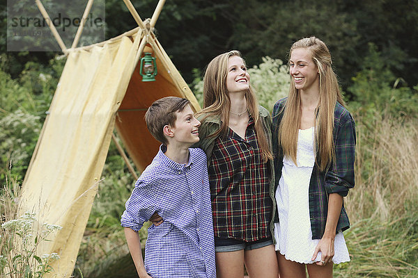 Brüder und Schwestern lächelnd im Campingzelt