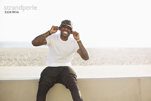 Afroamerikanischer Mann lächelnd auf Strandwand