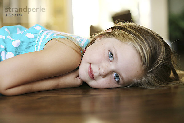 Nahaufnahme eines lächelnden Mädchens  das auf dem Boden liegt