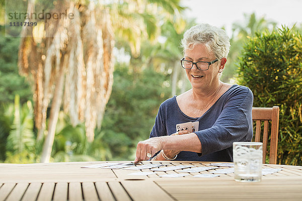 Kaukasische Frau spielt Karten im Freien