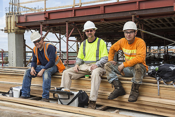 Lächelnde kaukasische Arbeiter auf einer Baustelle