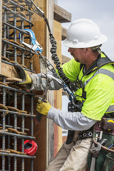 Kaukasischer Arbeiter  der auf einer Baustelle eine Mauer untersucht