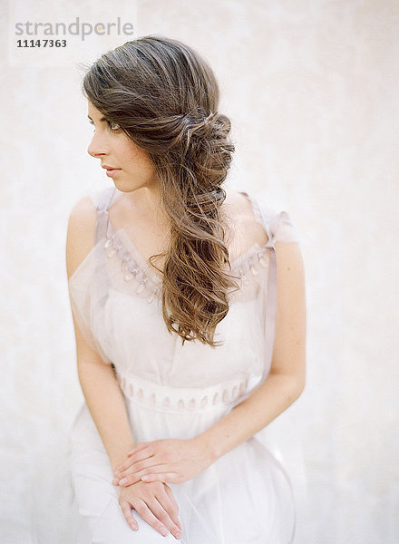 Braut mit gelocktem Haar im Hochzeitskleid