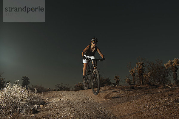 Frau fährt Mountainbike in der Wüste