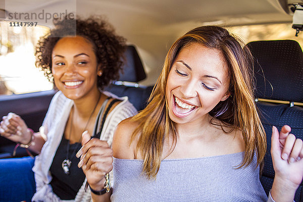 Frauen tanzen zusammen im Auto
