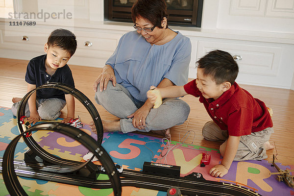 Asiatische Großmutter spielt mit Enkelkindern