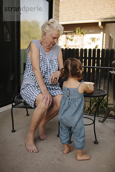 Großmutter und Enkelin spielen auf der Veranda