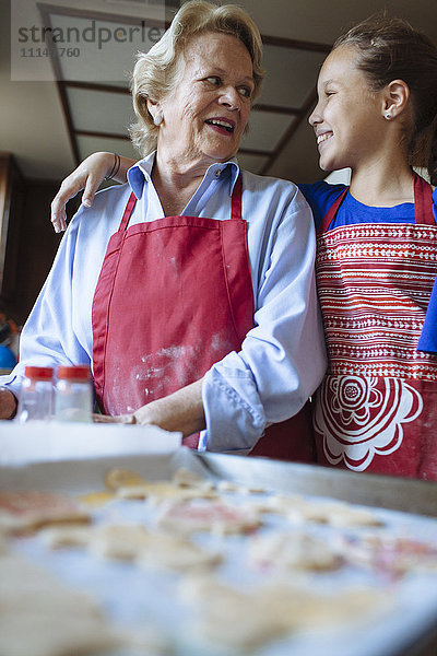 Großmutter und Enkelin backen Kekse in der Küche